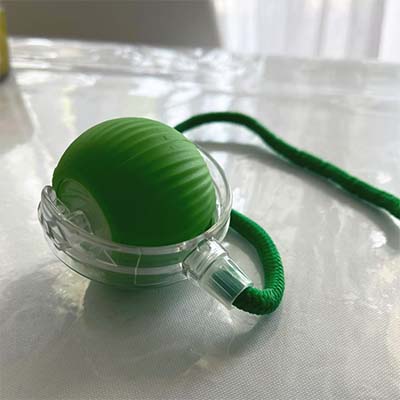 Green ball with a clear holder on a white surface